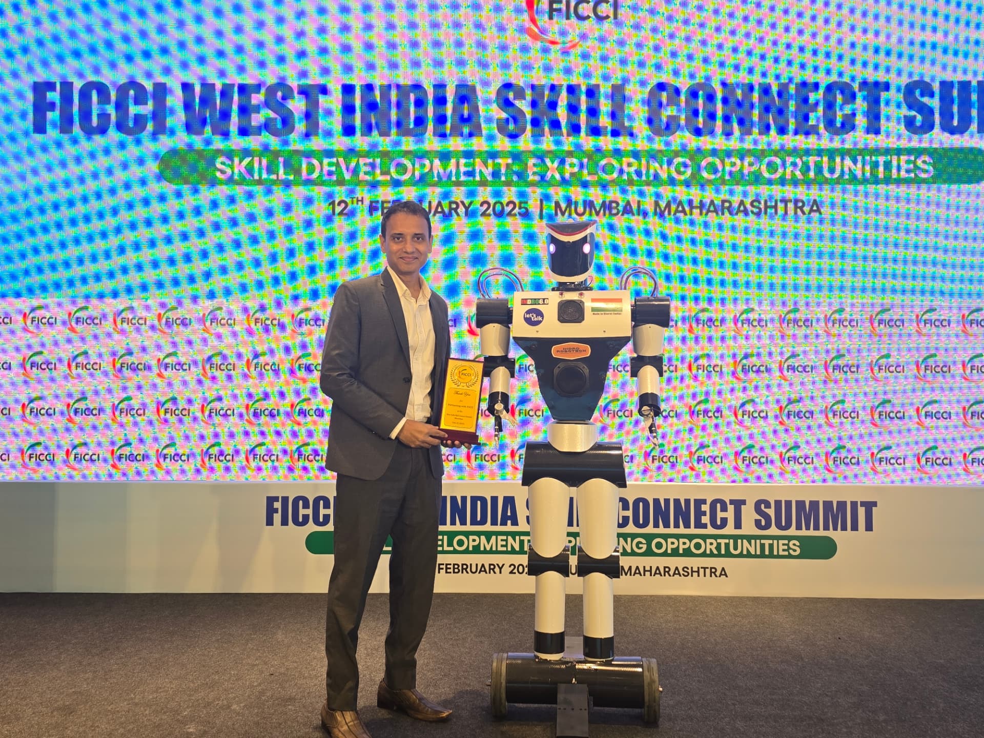 Mayank Saxena with a humanoid robot at the FICCI West India Skill Connect Summit, Mumbai 2025